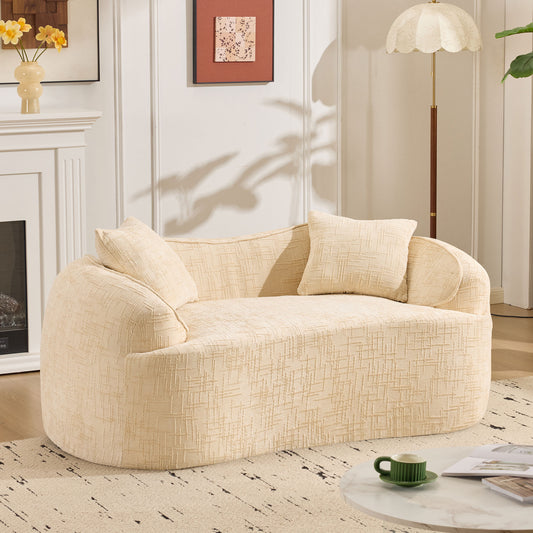 Beige curved two - person compress sofa. It has armrests on both sides, comes with two pillows, is suitable for small - sized apartments, and can be placed in the living room or bedroom.