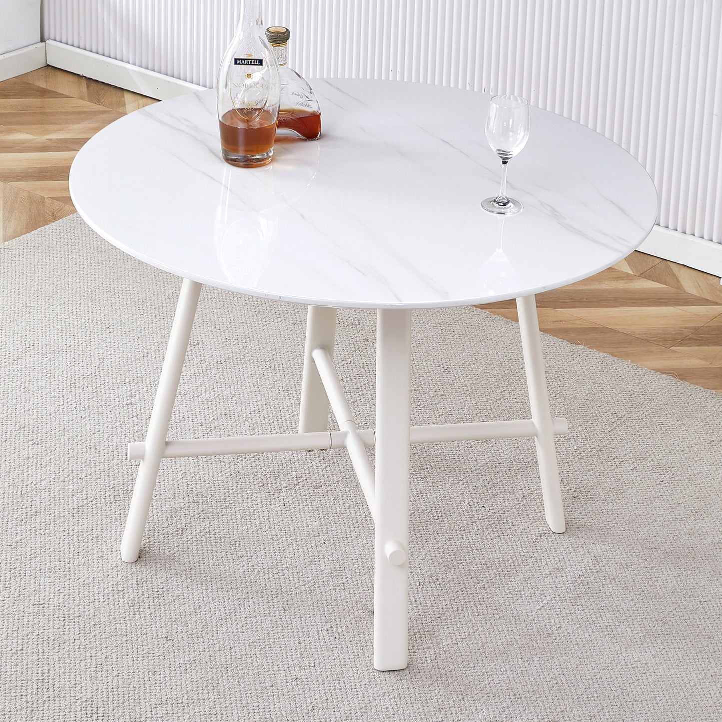 A modern minimalist circular dining table with a 42 inch diameter white patterned tabletop and white metal legs. Suitable for restaurants, living rooms, and conference rooms.