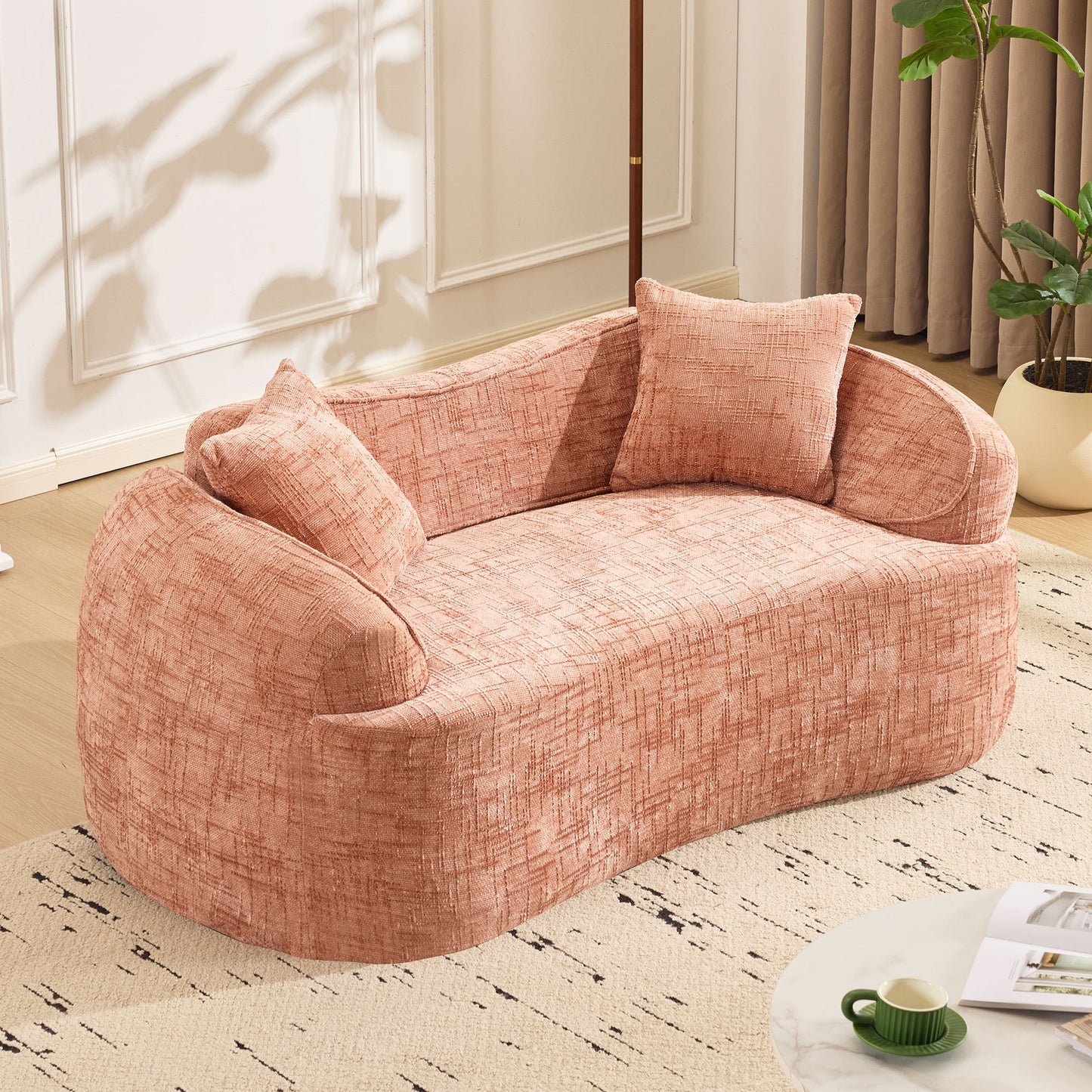 Pink curved two - person compress sofa. It has armrests on both sides, comes with two pillows, is suitable for small - sized apartments, and can be placed in the living room or bedroom.