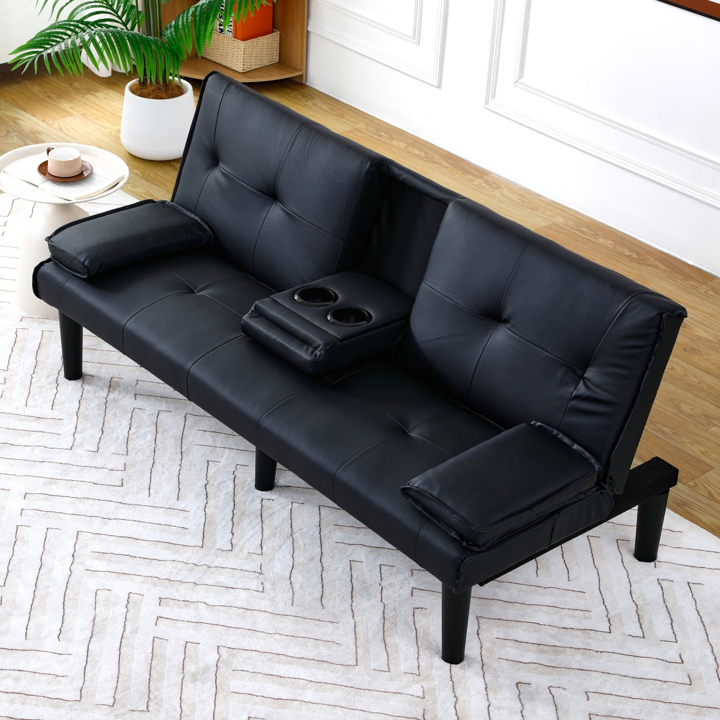 The 67-inch black PVC multi-functional sofa bed with a foldable and cup holder design makes it extremely convenient to turn the living room into a guest room